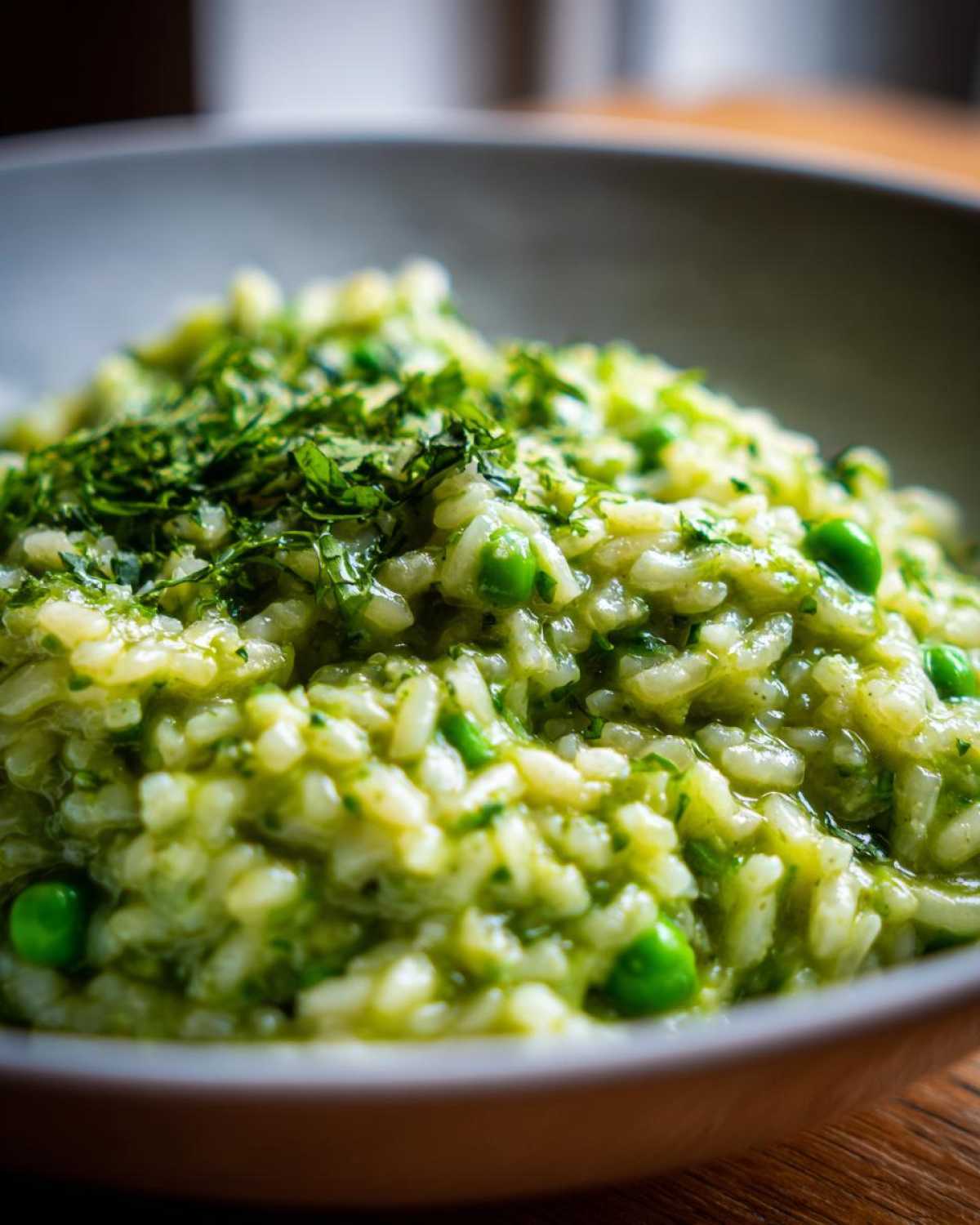 Close-up of creamy Spring Pea and Mint Risotto topped with fresh chopped herbs.