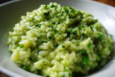 Close-up of creamy Spring Pea and Mint Risotto topped with chopped fresh herbs.