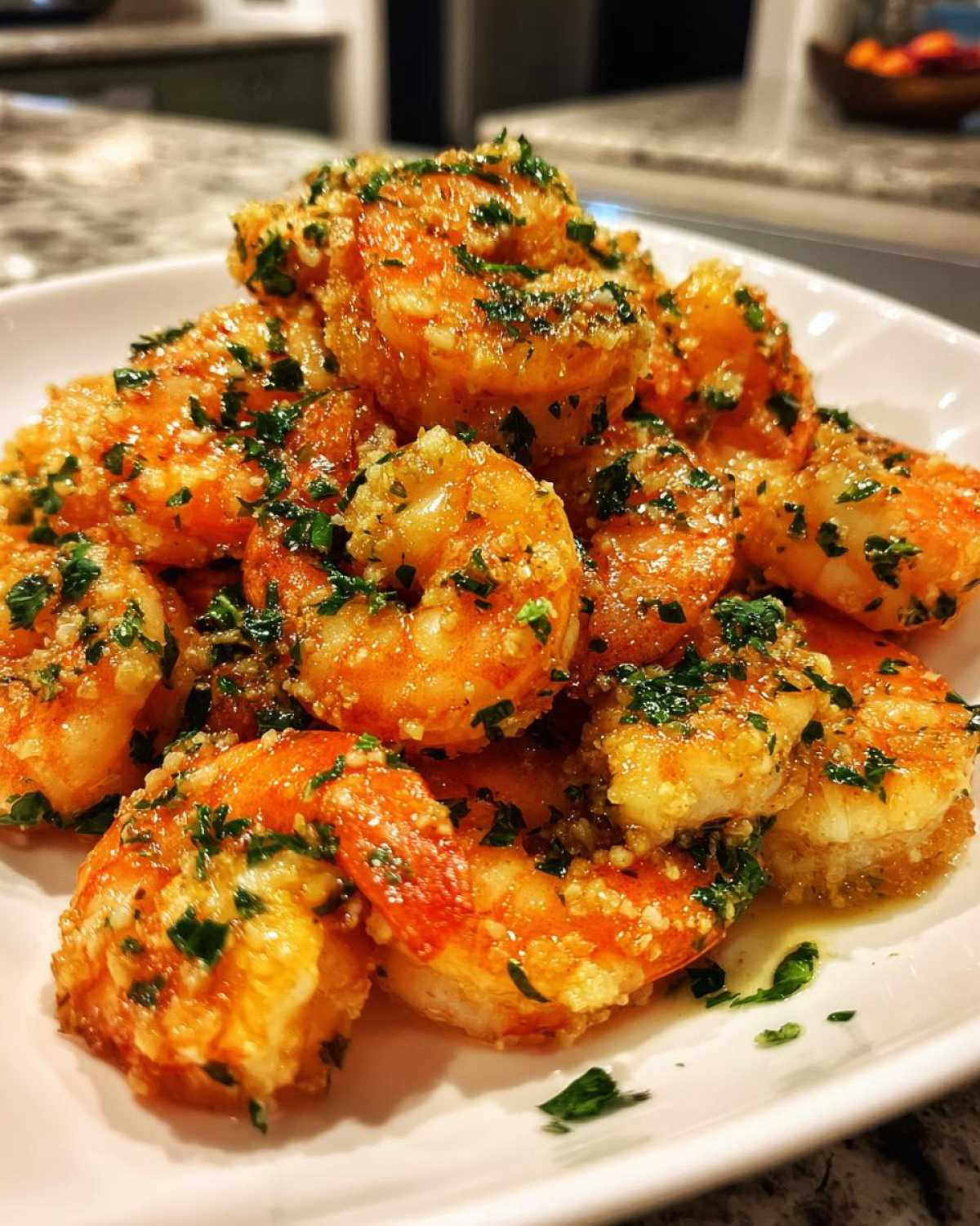 Close-up of a pile of Air Fryer Crispy Garlic Butter Shrimp coated in garlic and parsley.