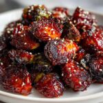 Close-up of Air Fryer Crispy Gochujang Brussels Sprouts, deeply caramelized and sprinkled with white sesame seeds.