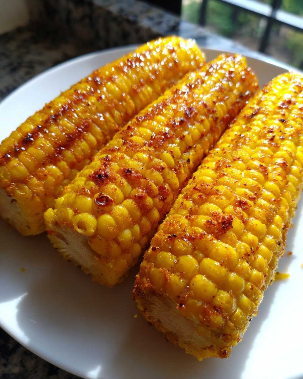 Three golden, seasoned corn ribs seasoned with spices, ready to eat, made using the Air Fryer Crispy Parmesan Garlic Corn Ribs recipe.