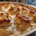 Close-up of golden-brown biscuits topping a creamy filling in a chicken pot pie with biscuits casserole dish.