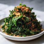 A mound of massaged kale topped with crunchy breadcrumbs and pine nuts for Copycat Kale Crunch Salad.