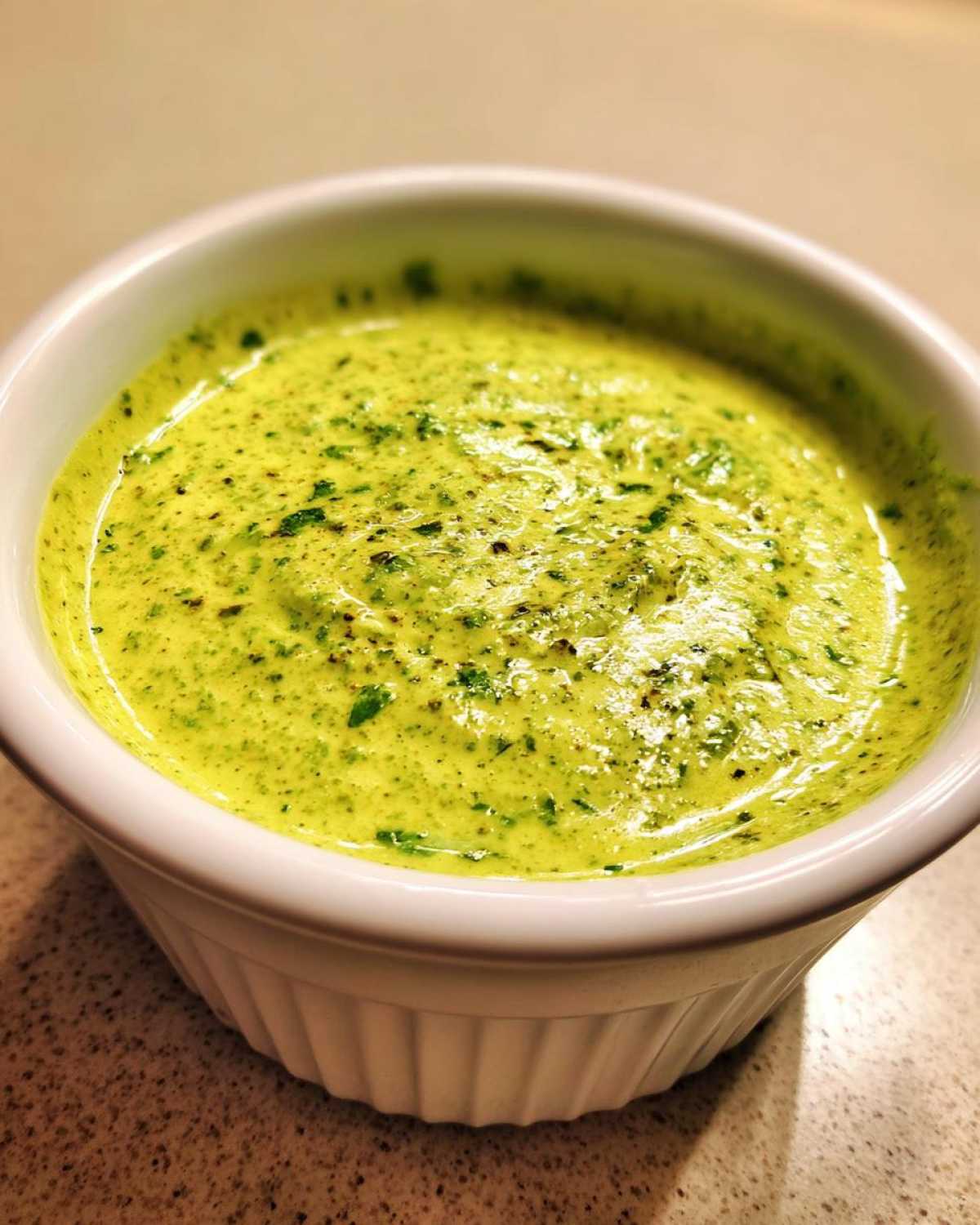 Close-up of bright green Easy 5-Minute Salsa Verde Yogurt Dip texture in a white ramekin.