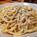 Close-up of spaghetti generously coated in creamy Easy Cottage Cheese Alfredo Sauce and sprinkled with herbs.