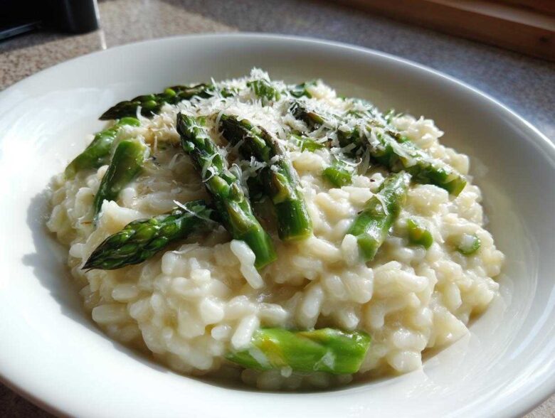 Close-up of a bowl of Easy Creamy Asparagus Risotto topped with bright green asparagus spears and grated Parmesan cheese.