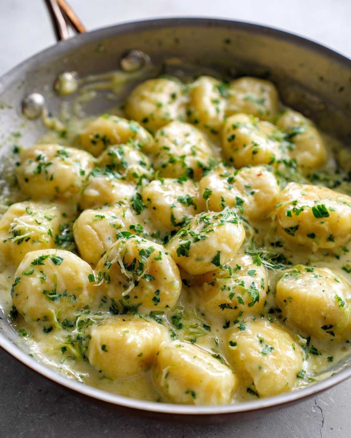 Close-up of Easy One-Pan Creamy Garlic Butter Gnocchi coated in a rich sauce and topped with fresh parsley.