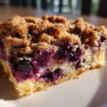 Close-up of a square slice of Easy Sheet Pan Blueberry Streusel Pancake showing moist cake, burst blueberries, and crunchy streusel topping.