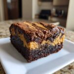 A thick, fudgy slice of peanut butter swirl brownies showing a rich chocolate base and creamy peanut butter layer.
