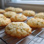 A batch of freshly baked Gluten-Free Lemon Thyme Shortbread Cookies cooling on a wire rack.