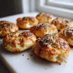 Close-up of several golden-brown High-Protein Cottage Cheese Bagel Bites topped with everything bagel seasoning.