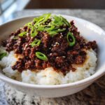 Close-up of Instant Pot Korean Beef and Rice Bowls topped with green onions and sesame seeds.