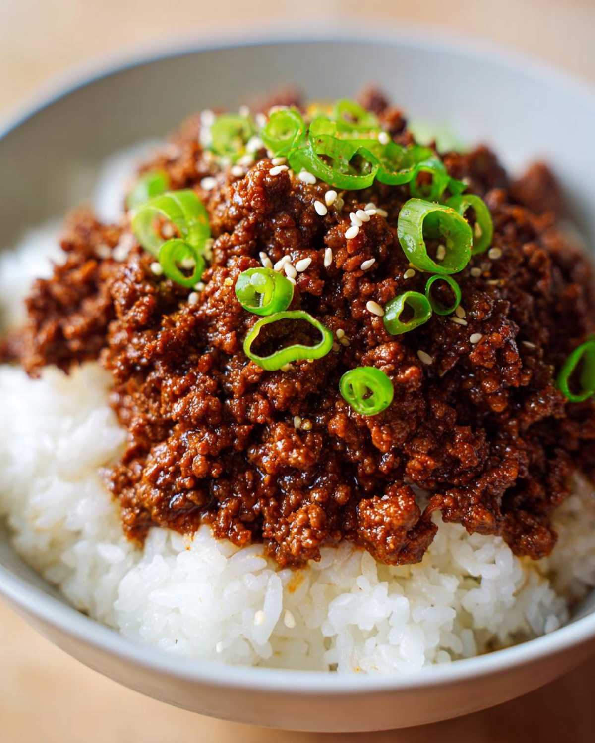 Close-up of Instant Pot Korean Beef and Rice Bowls topped with green onions and sesame seeds.