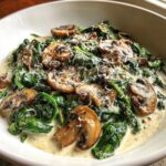Close-up of Keto Creamy Spinach Mushroom Skillet topped with grated Parmesan cheese.