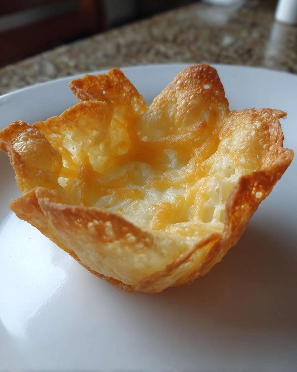 A single, golden-brown, crispy baked cheese shell shaped like a small bowl, perfect for Keto Crispy Cheese Taco Shell Bowls.