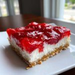 Close-up of a single serving of No-Bake Strawberry Pretzel Dessert Bars showing the pretzel crust, cream cheese layer, and strawberry topping.