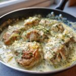 Close-up of seared chicken breasts simmering in a creamy, light green sauce with fresh dill, part of the One-Pan Creamy Coconut Lime Chicken recipe.