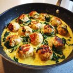 Close-up of One-Pan Creamy Lemon Garlic Turkey Meatballs simmering in a rich yellow sauce with wilted spinach.