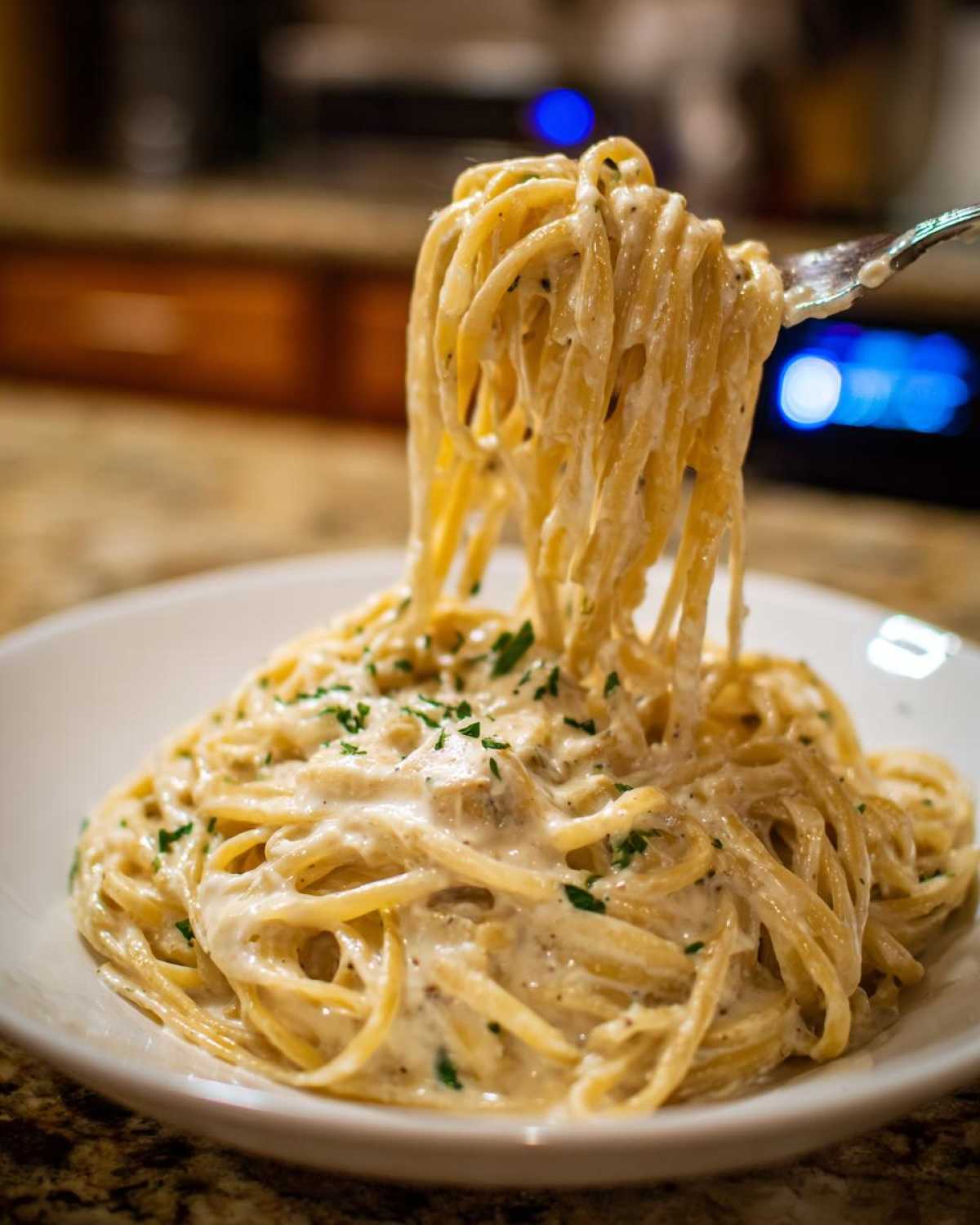 A fork lifts a generous portion of spaghetti coated in creamy Easy Cottage Cheese Alfredo Sauce, garnished with parsley.