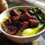 Close-up of a Vegan Crispy Sesame Tempeh Bowl featuring glazed tempeh cubes over rice and bok choy.